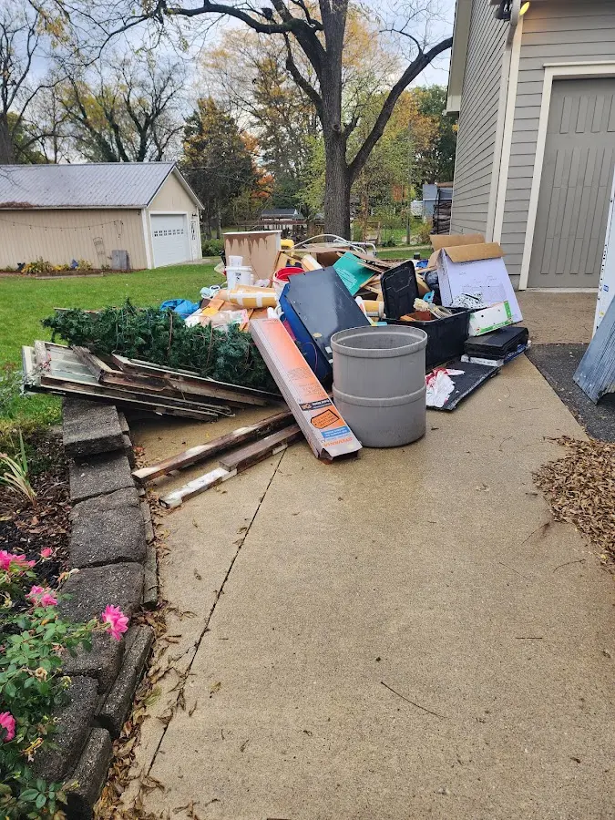 Dumpster being loaded with debris for 12 Yard Dumpster Rental in Kalkaska